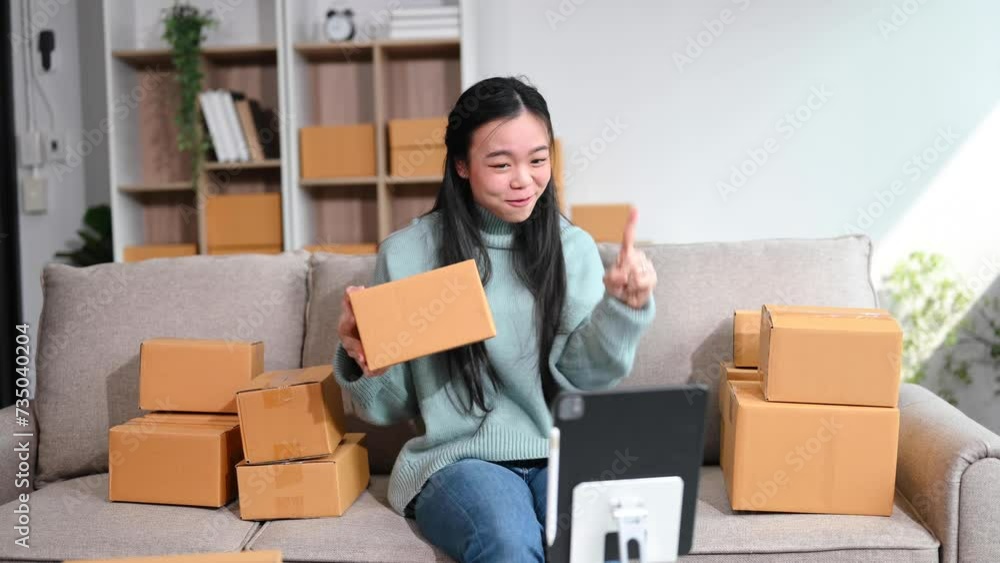 business woman prepare parcel box and standing check online orders for deliver to customer on tablet, laptop on sofa Shopping Online concept. business woman prepare parcel box and standing check online orders for deliver to customer on tablet, laptop on sofa Shopping Online concept.