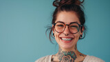 A joyful woman with glasses, a vibrant smile showing braces, and tattoos, exuding confidence and individuality.