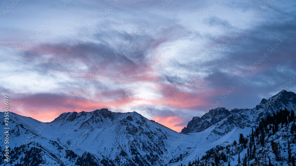 a beautiful pink dawn in the snowy mountains. early morning in the winter mountains