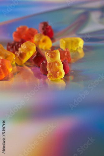 vitamins in gummy shape on holographic background photo