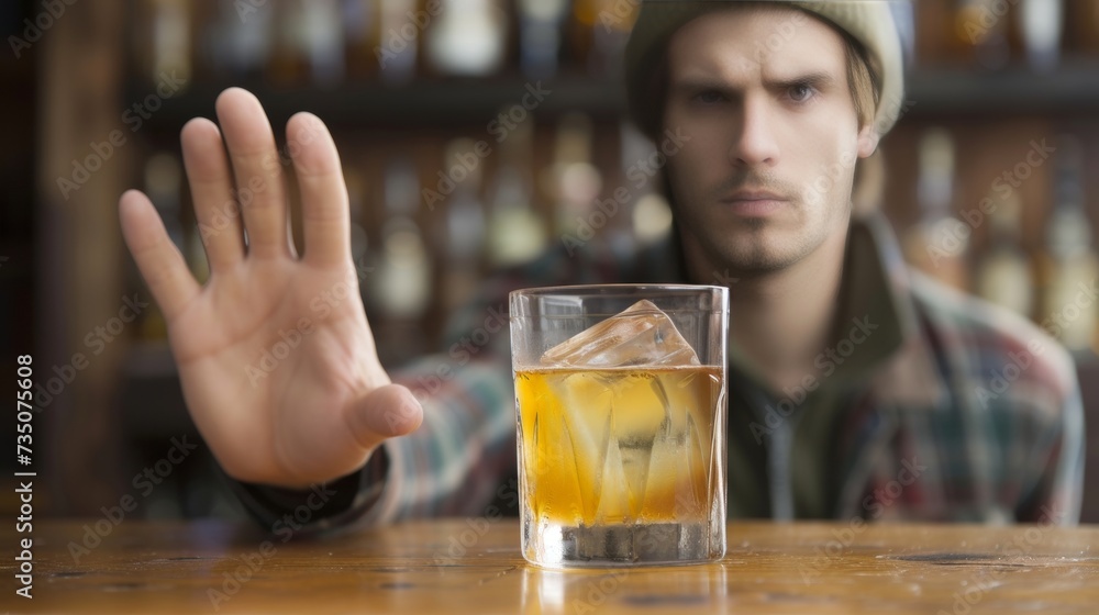 Man gesturing with hand to say no to alcohol, promoting sobriety and healthy lifestyle choices Man gesturing with hand to say no to alcohol, promoting sobriety and healthy lifestyle choices