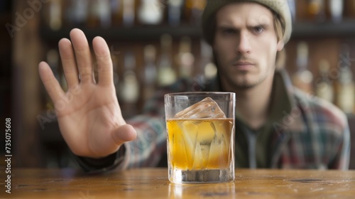 Man gesturing with hand to say no to alcohol, promoting sobriety and healthy lifestyle choices photo