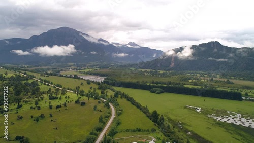 Aerial Idyllic Shot Of Clouds Under Green Mountains, Drone Flying Forward Over Tranquil Landscape - Chacabuco, Chile photo