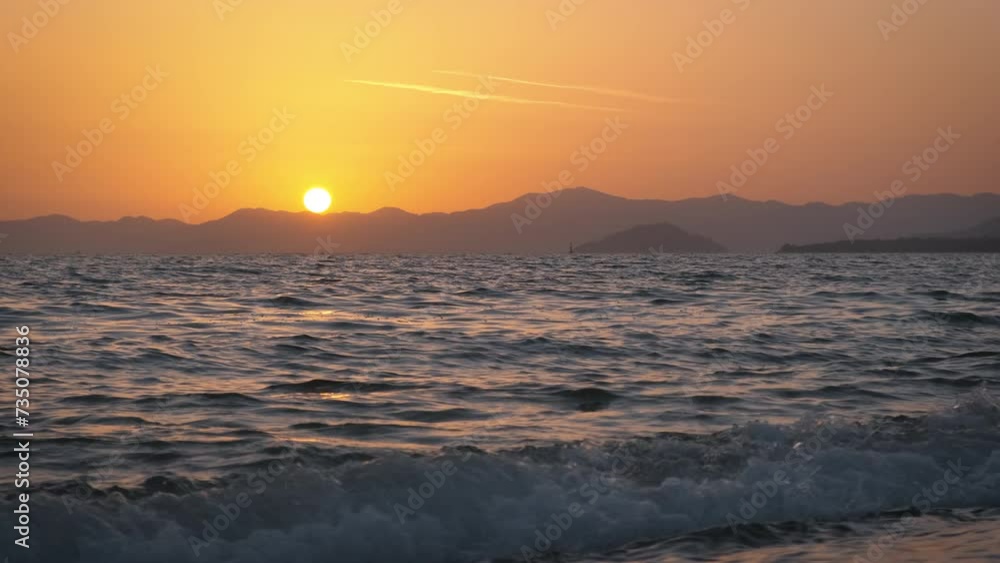 Morning sunrise orange under ocean silhouette. A view of bright morning red sunrise by foaming ocean waves silhouette on tropical island. Morning sunrise orange under ocean silhouette. A view of bright morning red sunrise by foaming ocean waves silhouette on tropical island.