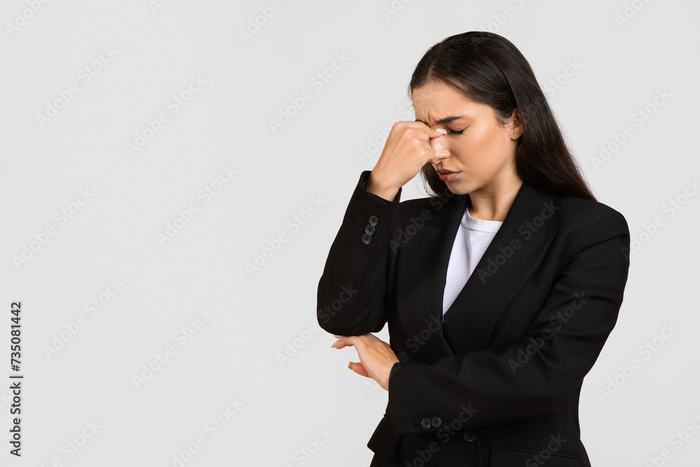 Worried businesswoman with hand on bridge of nose, eyes closed Worried businesswoman with hand on bridge of nose, eyes closed