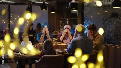 Ramadan Iftar Time, Caucasian Muslim Family Praying at the Restaurant Table