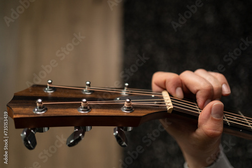 A closeup shot of a man's hand playing the guitar 