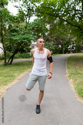 Young fitness man runner stretching legs before running © Jelena