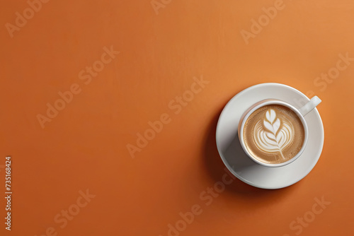 Top view latte coffee. White cup with foam, laptop on orange background. Perfect for graphic or product display. 