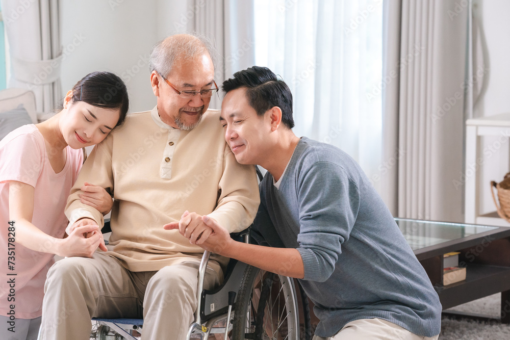 Gentle daughter and son are taking care and support help their retired and elderly father or dad on wheelchair at home, positive energy for senior patient, bonding between family, disability caregiver Gentle daughter and son are taking care and support help their retired and elderly father or dad on wheelchair at home, positive energy for senior patient, bonding between family, disability caregiver