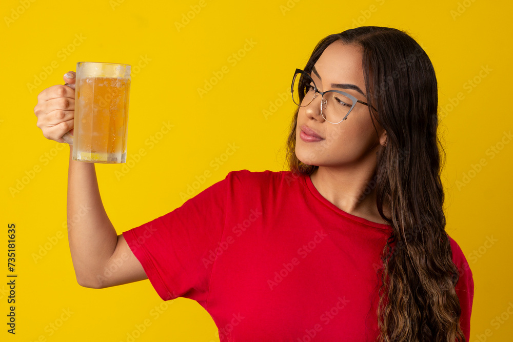 woman with long curly hair wearing glasses and holding glass of cold beer woman with long curly hair wearing glasses and holding glass of cold beer