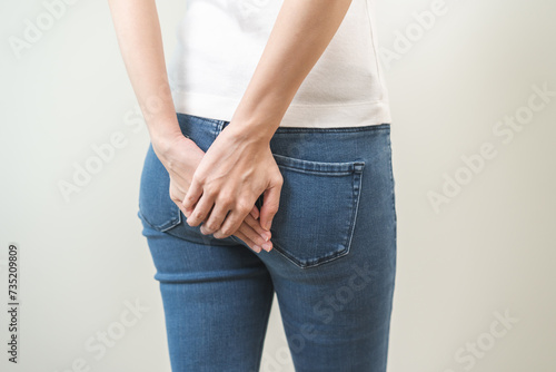 Health care, pain asian young woman suffering from hemorrhoid, anus, diarrhea and constipation, girl hand touching, holds butt, anal have abdominal, intestine problem, abscess disease and smell fart. photo