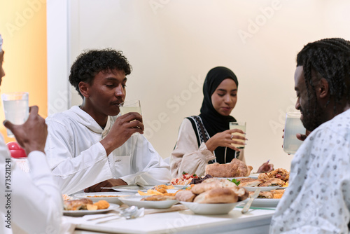 A traditional and diverse Muslim family comes together to share a delicious iftar meal during the sacred month of Ramadan  embodying the essence of familial joy  cultural richness  and spiritual unity
