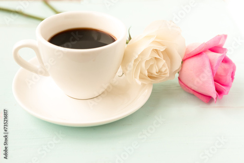 Coffee cup and roses on wooden table