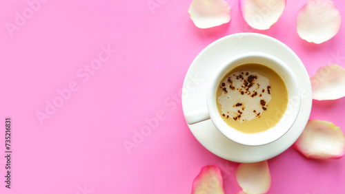 Coffee cup and roses petals on pink background. Valentines Day or Wedding greeting card