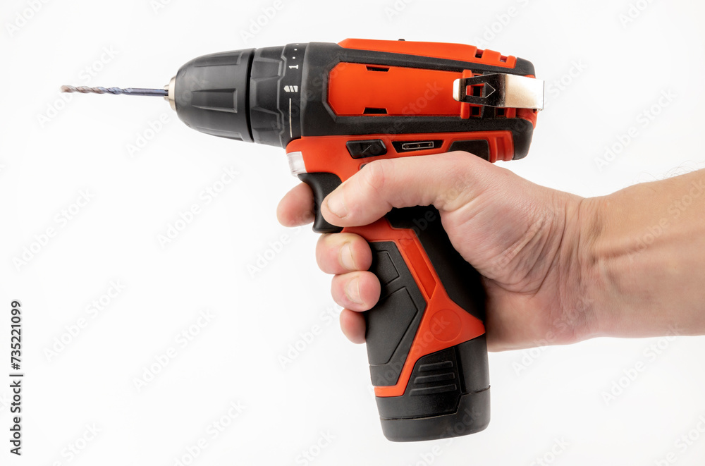 A cordless drill in the hand of a master. The concept of furniture production and repair. A cordless drill in the hand of a master. The concept of furniture production and repair.