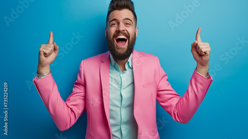 homem barbudo animado de terno rosa mostrando sim gesto isolado em azul