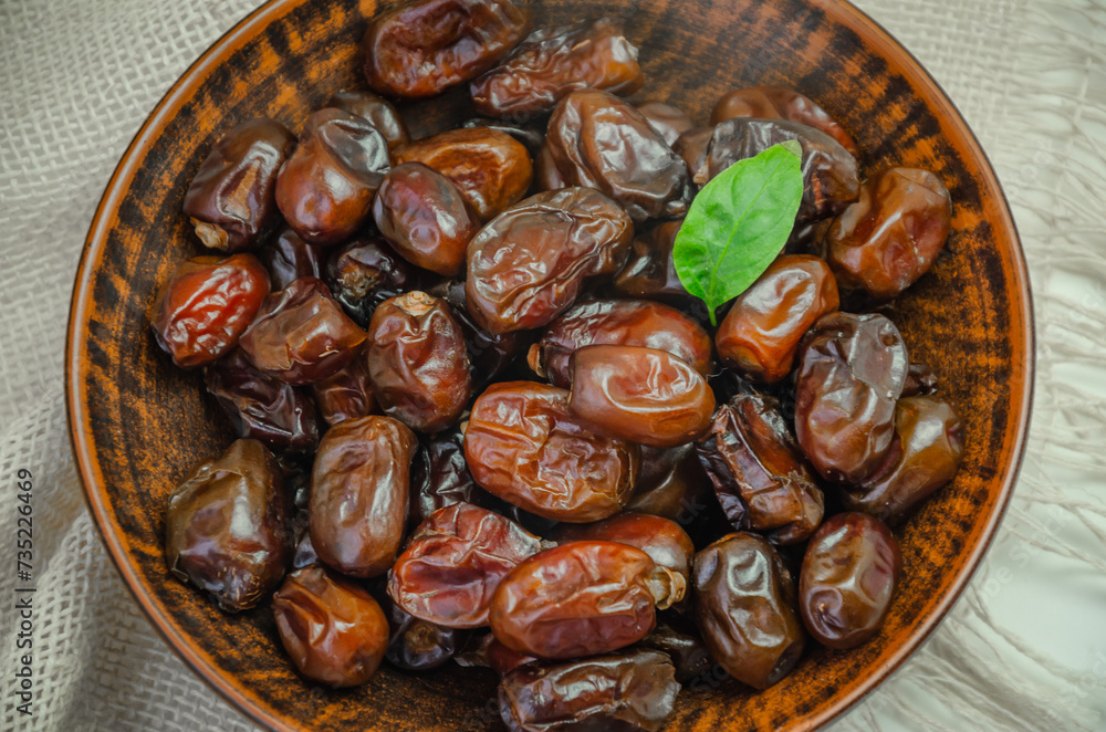 Fototapeta premium Dried dates in a ceramic plate, top view