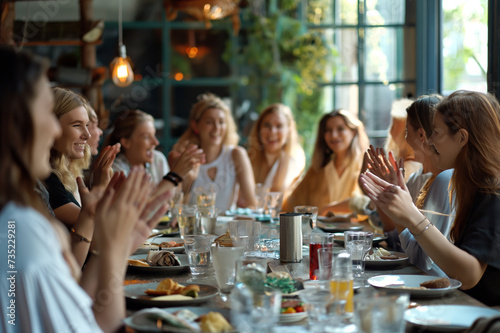 Many women at the table talking at a business meeting in a cafe, applauding