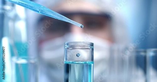 Super slow motion close up of scientist examines with pipette molecules of DNA sample substance in test tubes during biochemical analysis of experimental data research in laboratory at 1000 fps.