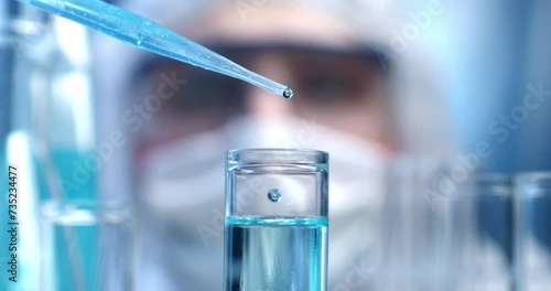 Super slow motion close up of scientist examines with pipette molecules of DNA sample substance in test tubes during biochemical analysis of experimental data research in laboratory at 1000 fps. photo