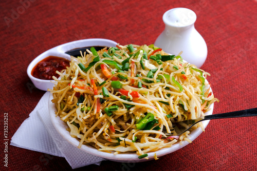 Schezwan Noodles or vegetable Hakka Noodles, or chow mein is a popular Indo-Chinese recipes, served in a bowl, Stir-fried noodles. photo