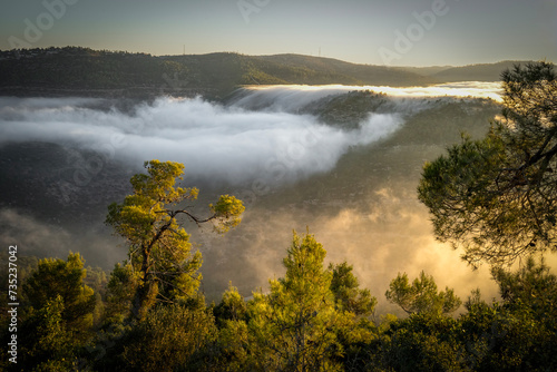Clouds Gliding into a Valley at Dawn