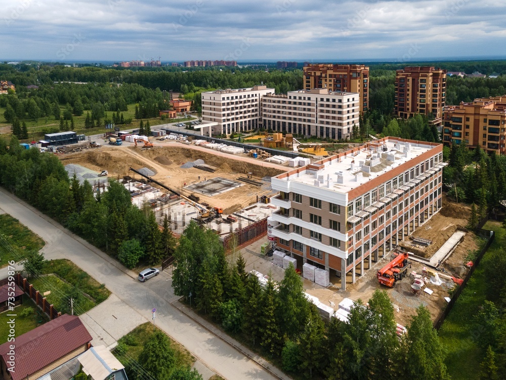 Fototapeta premium the construction site of an apartment building in the summer from a height