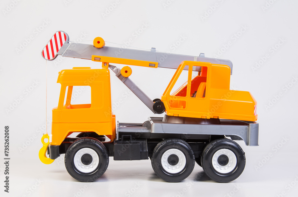 Lift truck. Multi-colored children's toys plastic trucks on a white background.