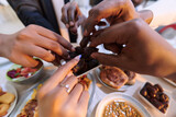 In a poignant close-up, the diverse hands of a Muslim family delicately grasp fresh dates, symbolizing the breaking of the fast during the holy month of Ramadan, capturing a moment of cultural unity