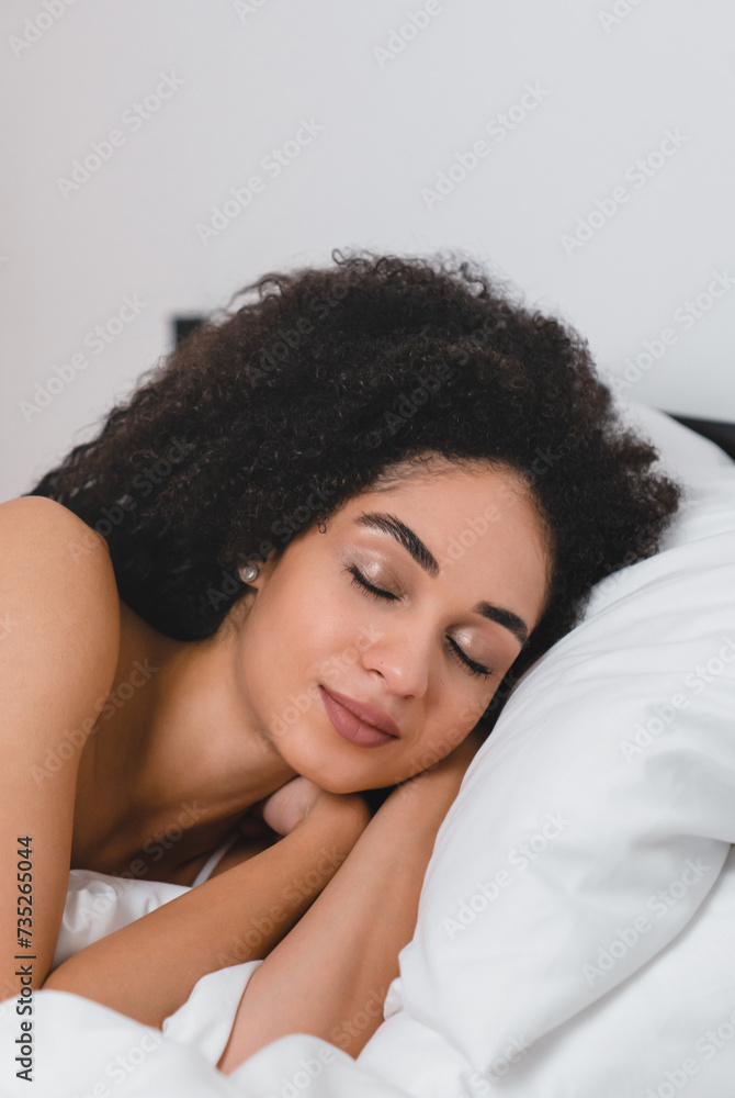 Vertical photo of young african woman lady female in white pajamas sleeping with deep phase of dream on orthopedic comfortable mattress in the bedroom Vertical photo of young african woman lady female in white pajamas sleeping with deep phase of dream on orthopedic comfortable mattress in the bedroom