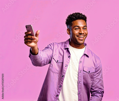 Young african american man using mobile phone on a pink background