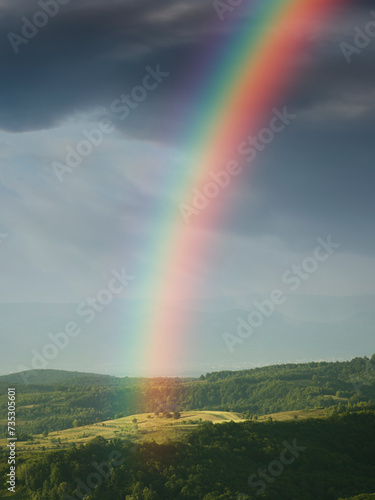 fantasy landscape with rainbow over the hills