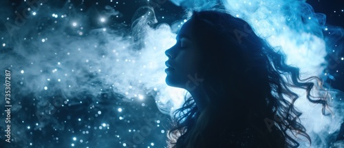 a woman with long dark hair standing in front of a blue and white background with stars and a cloud of smoke.
