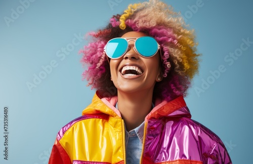 female in colorful jacket posing on blue background