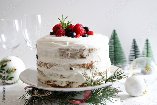 Tradizionale pandoro o panettone natalizio italiano con panna e frutti di bosco su sfondo bianco con decorazioni natalizie. Concetto di tradizioni di Natale e Capodanno. photo