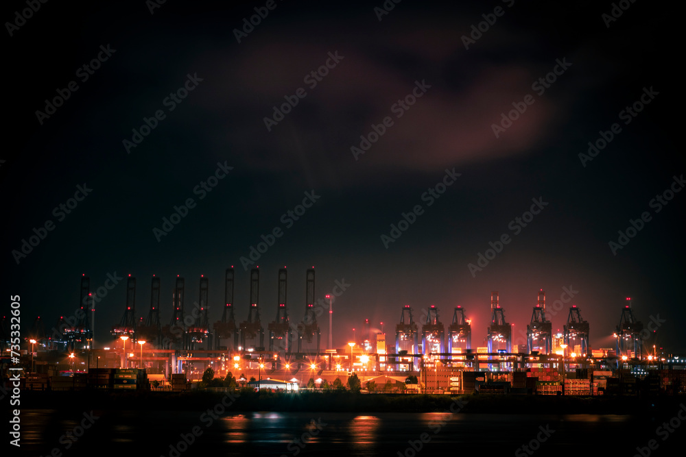 Night in the harbor of Hamburg with cranes and clouds and lights