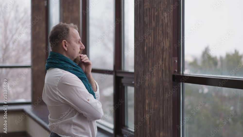 Gentleman contemplates winter vista. Lonely man immerses in profound introspection standing in room of private residence. Finding serenity in quietude Gentleman contemplates winter vista. Lonely man immerses in profound introspection standing in room of private residence. Finding serenity in quietude