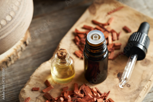 Bottles of essential oil with red sandalwood chips