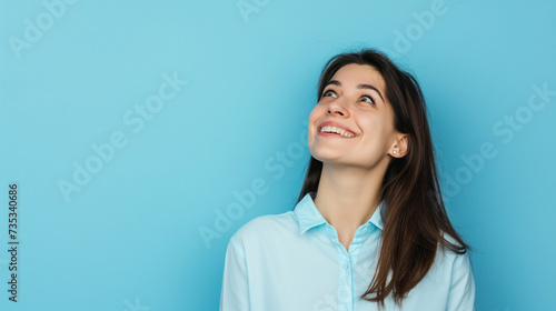Jovem alegre olhando para um fundo azul com espaço de cópia photo