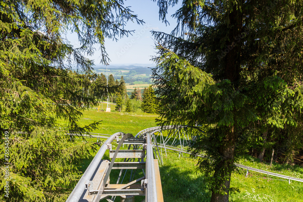 First person view of rollercoaster ride at mountain Wasserkuppe with mountain panorama in Rhön Mountains, Germany