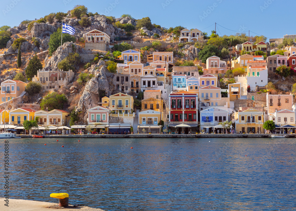 Φωτογραφία Multi-colored facades of houses in the Greek village Symi on a sunny day