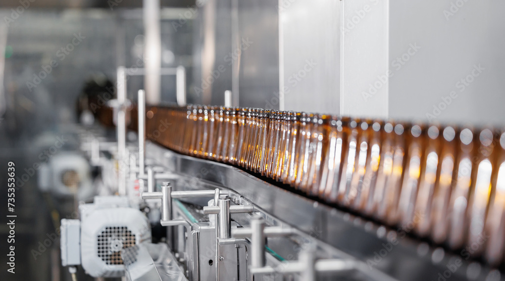 Naklejka premium Brown glass beer drink alcohol bottles, brewery conveyor, modern industrial food production line banner with sunlight
