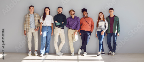 Εκτύπωση καμβά Portrait of a group of young diverse happy smiling friends students or colleagues in casual clothes standing together posing isolated on a gray background and looking positively at camera