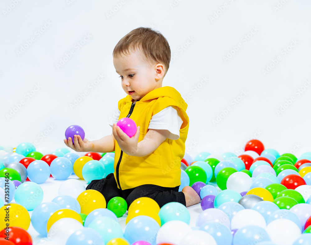 Little boy plays in pool of balls. Little boy plays in pool of balls.