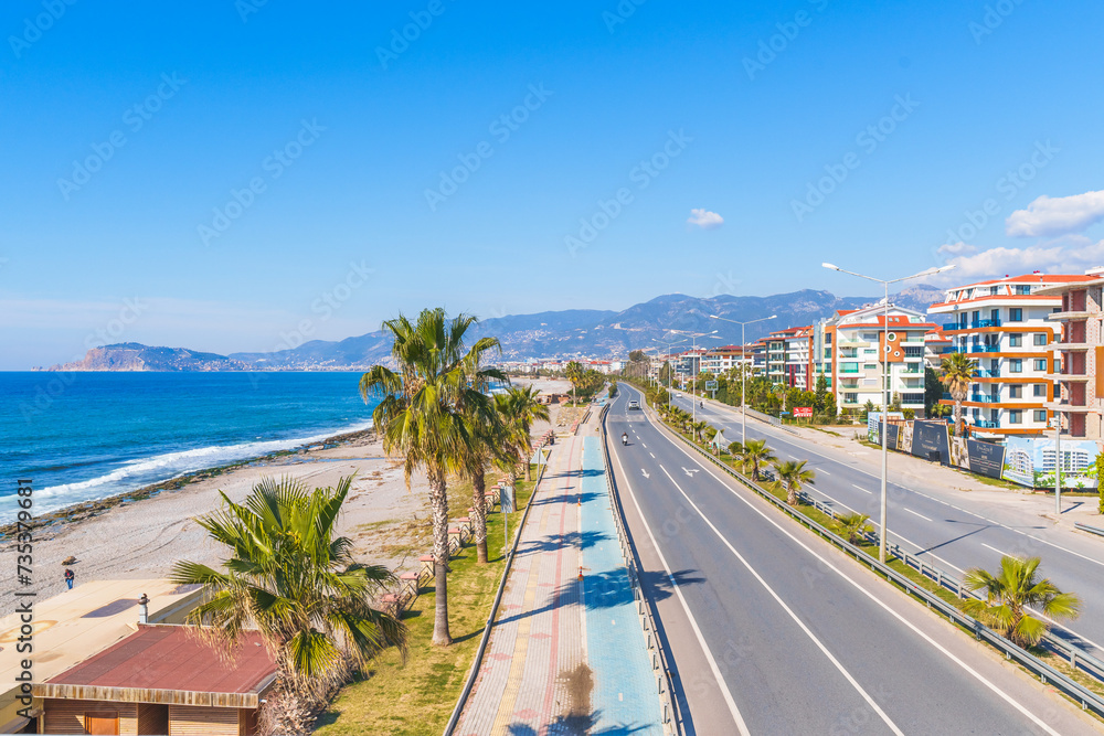 Empty Highway Road Next to a Blue Sea and Sandy Beach Under The Clear Sky in a Hot Sunny Summer day from a Pedestrian Stone Bridge