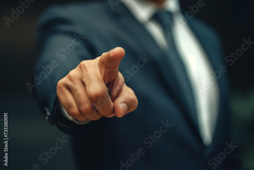 A male businessman in a business suit points his finger in the direction on a grey background