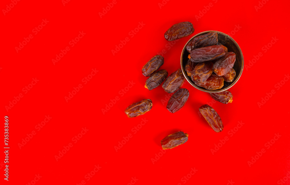 Top view heap of date fruit isolated studio red background copy space. Banner, advert, design element for Islamic holy month Ramazan or Ramadan. Delicious snack for ifar, breaking fast. Top view heap of date fruit isolated studio red background copy space. Banner, advert, design element for Islamic holy month Ramazan or Ramadan. Delicious snack for ifar, breaking fast.