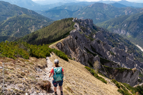 Hiker woman with panoramic view of unique rock formation in Hochschwab mountain range, Styria, Austria, Scenic hiking trail from Karlhochkogel to Sankt Ilgen. Escapism in Austrian Alps. Wanderlust