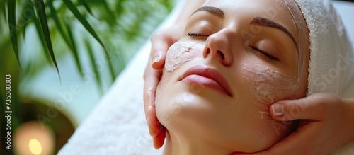 Woman enjoying a relaxing facial mask treatment at the spa for beauty and skincare therapy